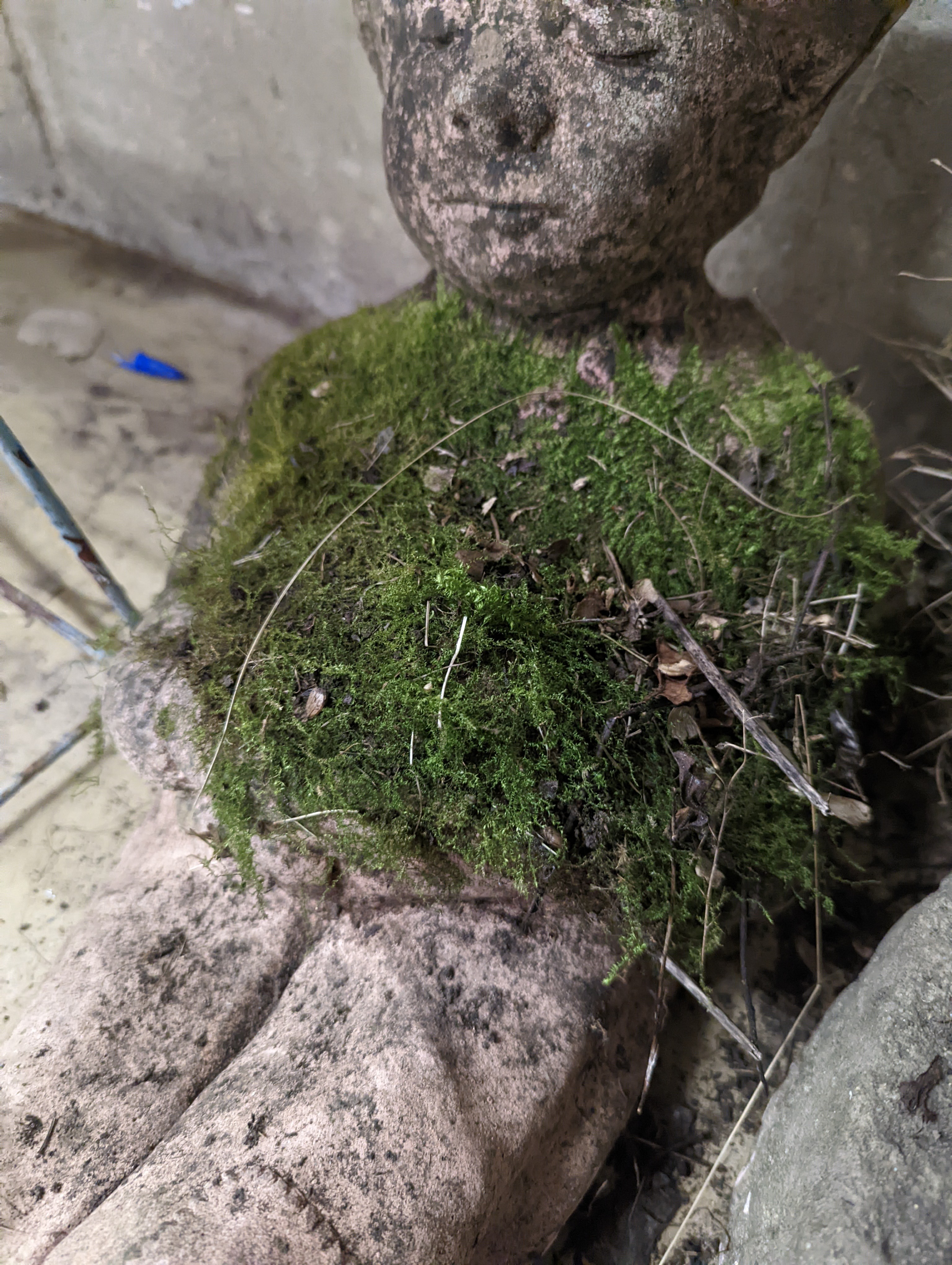 Two small circular mill stones, a reconstituted stone gargoyle and a terracotta reclining pixie garden ornament